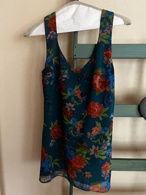 CAbi XS Sleeveless top in beautiful blue green with blue, red, and orange print
